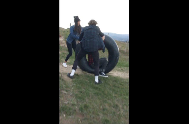 Image about Guy Rolls Down Hill in Tire Towards Car, Video